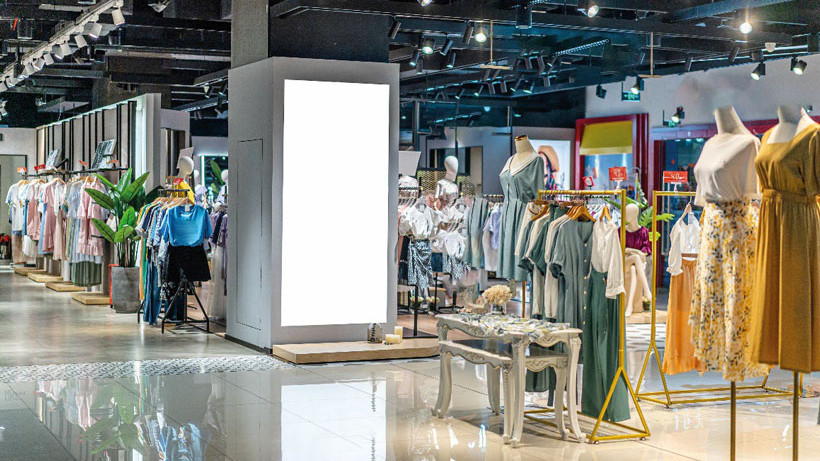 Hand bedient Laptop mit Robotik-Dashboard in Fabrikumgebung, Fokus auf Steuerungssicherheit und Datenanalyse