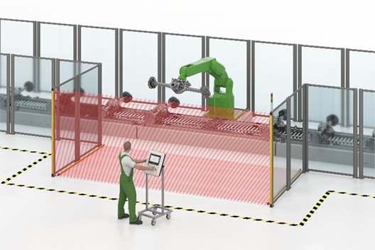 Industrieroboterzelle mit rotem Sicherheitslichtvorhang; Bediener steuert Anlage außerhalb des Schutzbereichs über Bedienpanel.