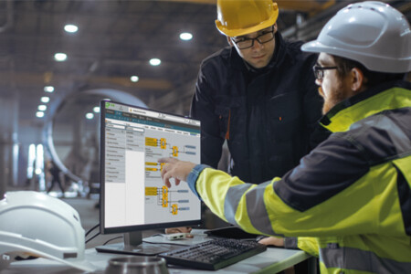 Zwei Ingenieure konfigurieren samos PLAN6 Sicherheitssteuerung am Monitor in Fabrikhalle.